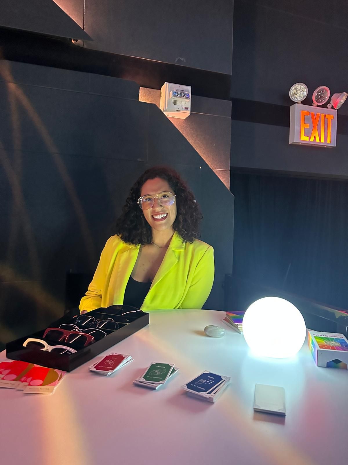 Kaide smiling at the reading table with tarot decks and a glowing lamp